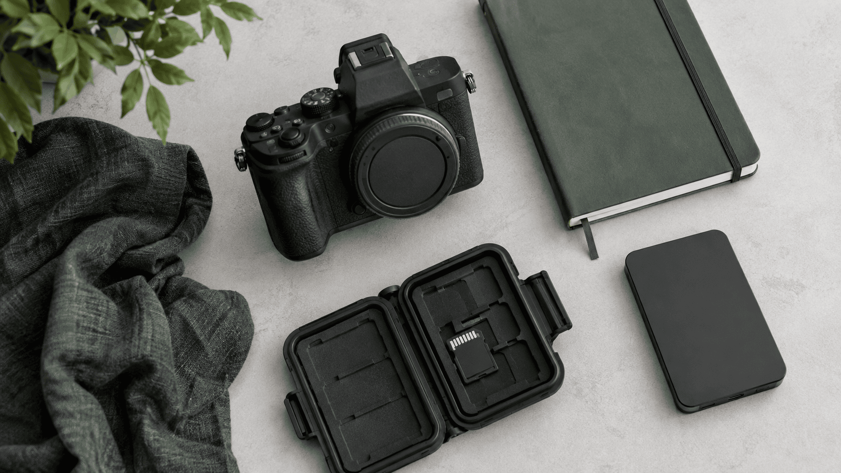 A powered-off camera, removed SD card in a case and separate portable drive.